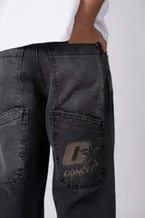 Jean de corte baggy y fit oversize, confeccionado en denim de algodón con lavado efecto gastado en color gris oscuro. Presenta costuras reforzadas en la zona de las rodillas y diseño de cinco bolsillos.