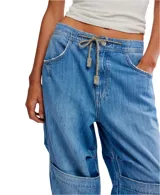 Jean de mezclilla azul claro, estilo cargo holgado con cordón ajustable en la cintura y paneles superpuestos en las rodillas.