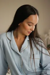 Camisa celeste con cuello clásico, cierre frontal con botones, manga larga con puños abotonados y bolsillo de parche en el pecho.