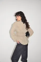 Camisa de gasa fina en tono beige con bordado de lentejuelas, cuello clásico, cierre frontal de botones y mangas largas con puños abotonados.