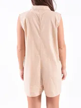 Monoprenda corta sin mangas, color beige, con cuello camisero y cierre frontal de botones. Presenta un corte holgado y relajado.