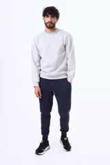 Buzo de felpa color negro, con cuello redondo, mangas largas y puños elásticos. Diseño básico y minimalista.