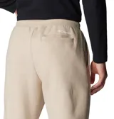 Pantalón de jogging color beige, confeccionado en mezcla de algodón, con cintura elástica ajustable mediante cordón, bolsillos laterales y bolsillo trasero. Presenta puños acanalados en los tobillos y un pequeño parche con el logo de la marca en la parte frontal.