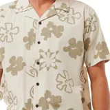 Camisa de manga corta color crema con estampado de flores marrones, cuello americano y cierre frontal con botones negros.