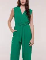 Enterito Luxology de crepÃ© color verde, sin mangas, con escote cruzado en V, cintura elastizada con lazo de ajuste y pantalÃ³n de corte amplio.
