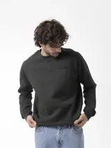 Buzo de cuello redondo verde oscuro, de manga larga, con detalle de costura en V en el cuello y pequeño parche engomado con la marca en el pecho.