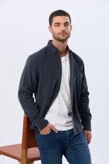 Camisa de manga larga confeccionada en pana fina de algodón, con cuello camisero, cierre frontal de botones y un bolsillo aplicado en el pecho.