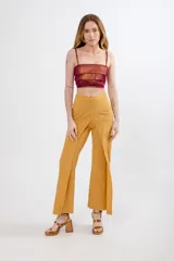 Pantalón mostaza de tela Slubb lycra de algodón elastizada, con corte palazzo y diseño cruzado en la cintura.