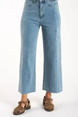 Jean de corte recto y tiro medio, confeccionado en denim de algodón con un toque de elastano. Presenta costuras verticales decorativas a lo largo de las piernas y un ruedo deshilachado.