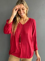 Jersey de punto fino con cuello en V, diseño oversize y mangas largas con corte a la altura del codo. Confeccionado en una mezcla de viscosa, algodón y lycra, ofreciendo una caída fluida y liviana.