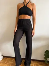 Pantalón negro de tejido calado con cintura elástica y corte acampanado.