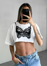 Remera crop top negra con estampa frontal de un bustier de encaje blanco.