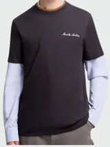 Remera de manga corta color negro con bordado Moncler Archive en el pecho, diseñada con un efecto de capas que incluye mangas largas de camisa en color celeste y cuello en tono marrón.