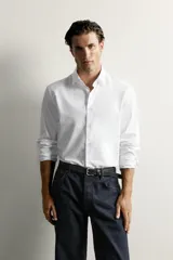 Camisa slim fit de algodón blanco con cuello italiano y manga larga con puño abotonado. Cierre frontal con botonadura.