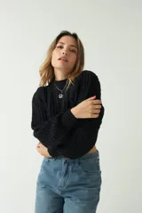 Sweater tejido de punto grueso color crema, con textura chunky, corte cropped, mangas abullonadas y puños ajustados.