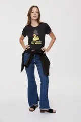Remera blanca de manga corta, con estampa frontal de un pato de hule con turbante y labios pintados, acompañada de la frase "In all else fails, denial".