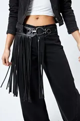 Cinturón negro de cuero sintético con flecos largos, hebilla metálica plateada y detalles de tachas.