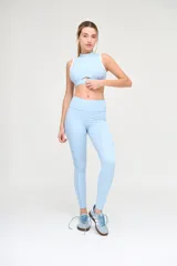 Top deportivo celeste con cuello alto y espalda deportiva con ribete blanco.