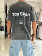 Remera oversize de efecto gastado color celeste, con cuello redondo y mangas cortas. Estampado frontal pequeño con el texto "Top Style" y gran estampado en la espalda con el mismo texto, la frase "Dream big. Work hard. Make it real.", el año "SINCE 2021" y un código de barras.