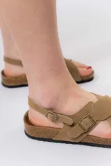 Sandalias de cuero marrón con tiras cruzadas, base de corcho y suela antideslizante.