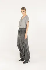 Pantalón amplio de popelina de algodón y satén de viscosa, en tono gris con efecto de teñido en frío. Presenta cintura elastizada, diseño de pierna ancha con frunces laterales y cordón de ajuste en el ruedo que permite fruncirlo en los tobillos.