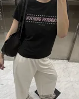 Remera de manga corta negra con diseño gráfico en la espalda que muestra dos gatos animados con cuchillos y el texto 'Kaboa Industries'.