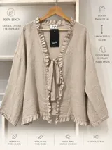 Blusón estilo saco de lino color beige, con mangas largas amplias, escote en V y volados fruncidos a lo largo de la abertura frontal. Cuenta con un lazo ajustable en el pecho.
