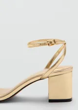 Sandalia de tacón cuadrado color dorado, con tira delgada en la parte delantera y pulsera ajustable con hebilla en el tobillo.