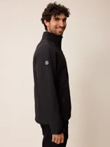 Campera softshell color gris, con cierre frontal completo, cuello alto y bolsillos laterales y en el pecho con cierre. Cuenta con logo bordado en el pecho y ajuste en los puños.