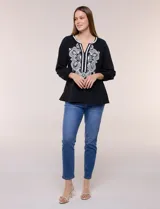 Blusa negra de silueta suelta con escote en V y elegante bordado frontal de arabescos en color blanco. Presenta mangas tres cuartos abullonadas con puños elastizados y diseño de inspiración boho.