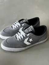 Championes urbanos de caña baja Converse Net Star, color gris con detalles en blanco y negro. Capellada de lona de algodón combinada con suede, logo Star Chevron aplicado y suela de caucho.