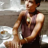 Aros tipo botón dorados con textura irregular que simula la superficie de un molusco.