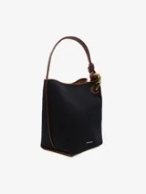 Bolso de hombro tipo bucket color crema, con detalles en cuero negro y herrajes dorados.