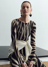 Vestido midi de poliéster con estampado animal print tipo cebra en tonos marrón y negro, escote redondo y manga larga.