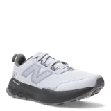 Championes de trail running New Balance Garoé V2 de mujer, en color gris claro con suela y entresuela en tono oscuro. Incorporan tecnología Fresh Foam X para mayor amortiguación, suela AT Tread con goma Hydrohesion para tracción en terrenos difíciles y refuerzo Toe Protect en la puntera.