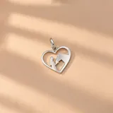 Dije de plata 925 en forma de corazón con la silueta recortada de una mujer y un caballo mirándose.