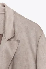 Blazer cruzado de mujer color marrón oscuro, con cuello solapa, manga larga y bolsillos delanteros con solapa.