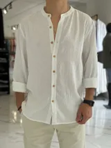Camisa de lino blanca de manga larga con cuello mao y botones frontales de madera.