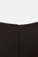 Vestido mono corto de cuello redondo y sin mangas. Presenta un diseño entallado con detalle de cinturón del mismo tejido con hebilla metálica y cierre de cremallera oculta en la espalda.