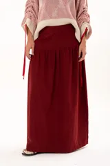 Pollera larga de corte recto con detalle de volado en la parte inferior, confeccionada en tela color bordó.