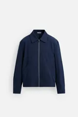 Cazadora bomber azul marino de corte regular fit, confeccionada en tejido de algodón. Presenta cuello solapa, manga larga con puño ajustable de botón, bolsillos de vivo en la cadera, bolsillo interior y bajo con elástico. Cierre frontal con cremallera.