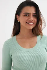 Sweater color beige de tejido de punto acanalado, con cuello redondo y mangas largas.