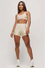 Top deportivo color beige, de breteles finos y espalda deportiva.