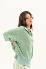 Buzo de punto color verde menta, con cuello polo y escote en V, mangas cortas y diseño holgado.