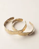 Pulsera tipo esclava abierta con diseño rústico y acabado irregular, fabricada en bronce y alpaca.