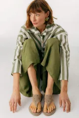 Sandalias de cuero color beige con apliques metálicos redondos.