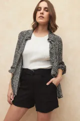 Short color beige de tiro alto con cinto incluido, de tela liviana y bolsillos laterales.