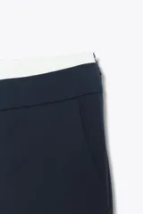 Pantalón de tiro alto color gris oscuro con finas rayas verticales blancas (pinstripe). Posee pernera recta y ancha, y doble cintura elástica con tejido combinado.