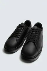 Zapatilla urbana monocolor de diseño minimalista con cordones al tono, puntera redondeada y suela con volumen.
