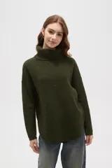 Polera de tejido de punto con cuello alto, diseño holgado y mangas largas. Presenta una textura de relieve tipo waffle en color natural.